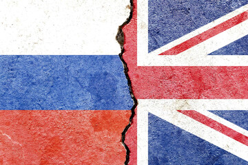 A Russian and UK flag on a cracked wall- politics, war, conflict concept