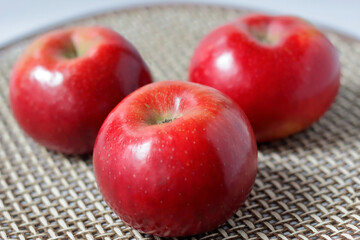 three red apples on a table