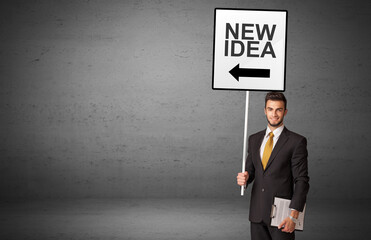 business person holding a traffic sign with NEW IDEA inscription, new idea concept