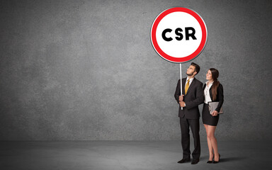 Young business person holdig traffic sign with CSR abbreviation, technology solution concept