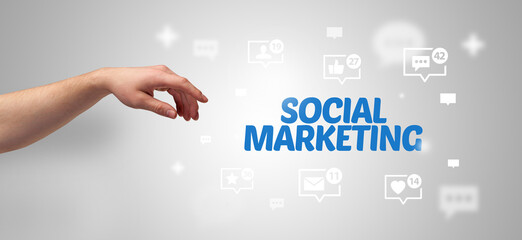 Close-Up of cropped hand pointing at SOCIAL MARKETING inscription, social networking concept