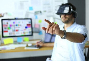 Young male software programmer testing a new app with 3d virtual reality glasses in office.