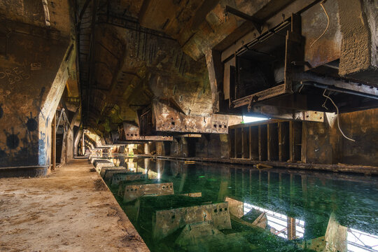 Old industrial plant with coal bunkers and cellar filled with toxic water