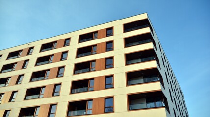 Facade of new apartment building. Glass balcony and clean look of modern architecture building with blue sky background.