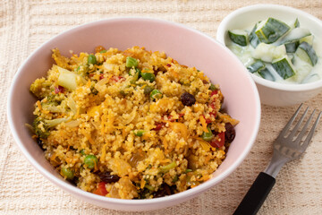 Bowl with Moroccan couscous accompanied by cucumber in yogurt sauce