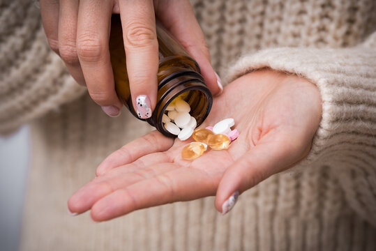 Close Up On Woman Hands Taking Vitamins, Minerals And Supplements For Vegans From The Jar. B12, D3, K2