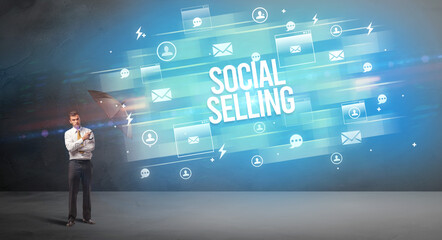 Handsome businessman defending with umbrella from SOCIAL SELLING inscription, new age media concept