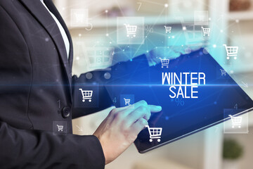 Fototapeta na wymiar Young person makes a purchase through online shopping application with WINTER SALE inscription