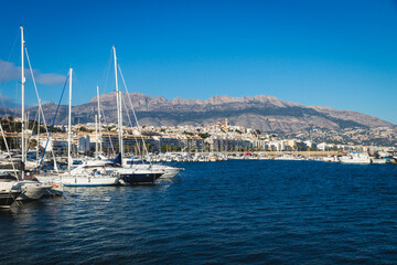 Fototapeta na wymiar Boats at the port of Altea with view on mountain range with old city and cathedral, Altea, Costa Blanca, Spain