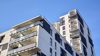Fototapeta premium Facade of new apartment building. Glass balcony and clean look of modern architecture building with blue sky background.