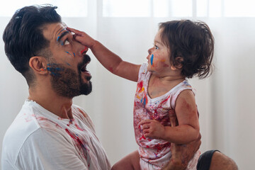 Mixed race kid and parent or father day concept. Enjoyment daughter playing color and holding hand...