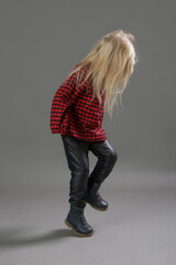 Fashion studio portrait of adorable 3 years old girl singing and dancing