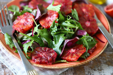 Soft focus. Fresh juicy salad with arugula and red orange. Vegan salad. Slimming food.