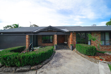 Fototapeta na wymiar Residential house in Dural a country suburb in Sydney NSW Australia with lush green trees and grass 