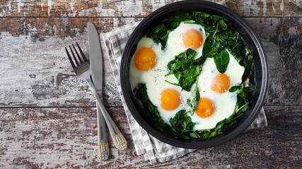 Eggs with spinach in a frying pan. Healthy breakfast. The keto diet.