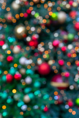 A vertical shot of a blurred bright festive Christmas tree background with bokeh effect