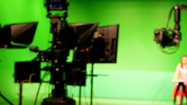 abstract blurred of broadcast camera in studio with greenscreen at TV station.
