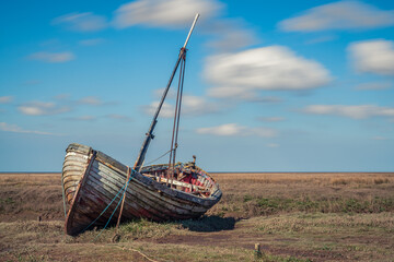 An old wooden sailing boat in Thornham Old Harbour, Norfolk, England, UK