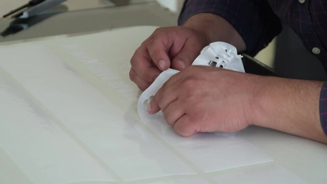 Foil cut in plotter. The man who removed the cut patterns on the cutting foil. The man removing the cut shapes from the vinyl.