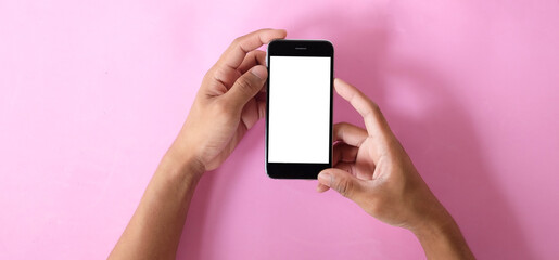 Close up view of male hands using smart phone with modern office blurred background. Blank screen monitor for graphic display montage.