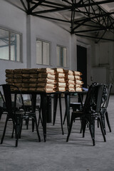 A pile of coffee craft bags on a black loft table. Packaging, storage, distribution concept