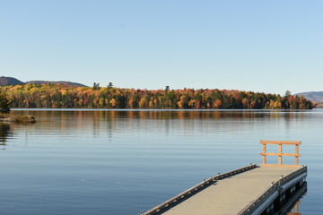 Obraz premium Umbagog lake with Fall color on the outer edge and a pier in the front
