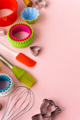 Set of various baking utensils on pink background