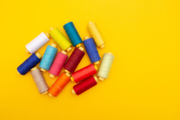 Color sewing threads on yellow background 