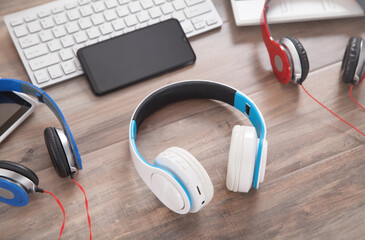 Blue, white, red headphones on the wooden background.