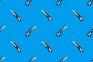 Stationery knives seamless pattern on a blue background.