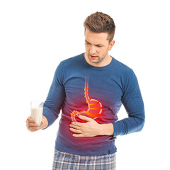 Young man with glass of milk suffering from heartburn on white background - obrazy, fototapety, plakaty