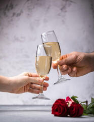 Crop close up of man and woman hold glasses with champagne or vine clink greet congratulate with valentines day against white background. Celebration concept.