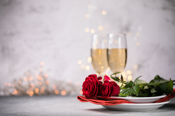 Valentines day table setting  red roses and champagne glasses on concrete background. Valentine 's...