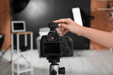 Female hand with modern photo camera in studio