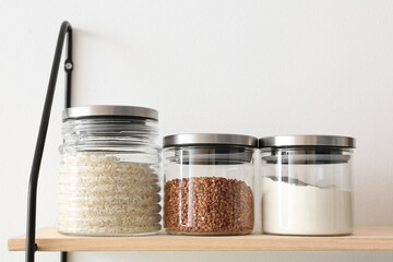Jars with products on kitchen shelves