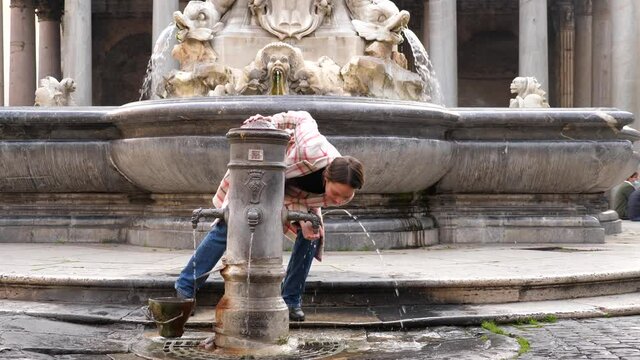 Ragazza turista si ferma a bere ad una fontanella davanti ai monumenti di Roma, Italia
Adolescente beve alla fontana davanti al Pantheon
