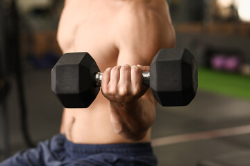 Handsome muscular man training in gym