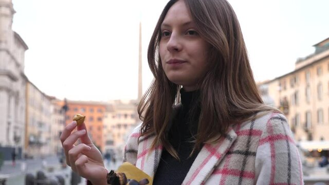 turista mangia delle castagne mentre si gode il panorama dei monumenti di Roma
Adolescente mangia una castagna mentre visita Roma durante l'inverno