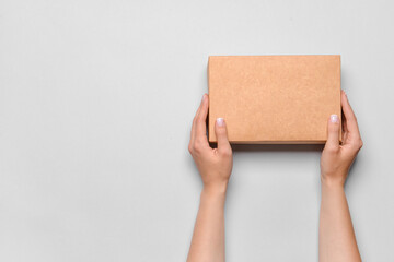 Hands with cardboard box on white background