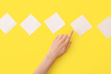 Female hand with blank papers on color background