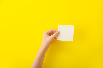 Obraz premium Female hand with blank paper on color background