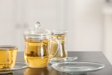 Cups of green tea and teapot on table