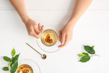 Female hands with cup of green tea on table