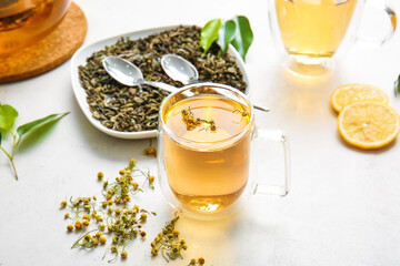 Cup of green tea with herbs on table