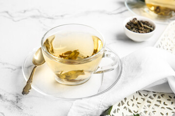Cup of green tea and spoon on table