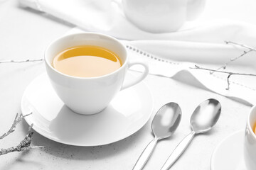 Cup of green tea and spoons on table