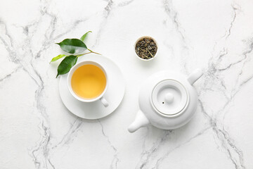 Obraz na płótnie Canvas Cup of green tea and teapot on table