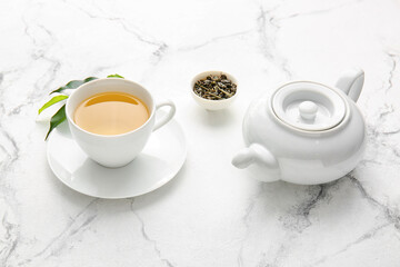 Fototapeta na wymiar Cup of green tea and teapot on table