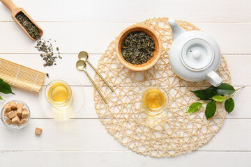 Composition with glasses of green tea and teapot on table