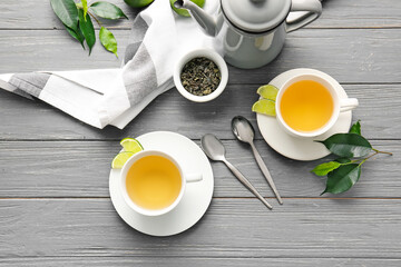 Composition with cups of green tea on wooden table